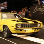 Barrett Jackson auction with yellow yanko vehicle across block
