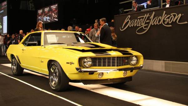 Barrett Jackson auction with yellow yanko vehicle across block