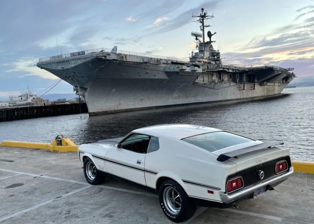 ford mustang in front of battleship