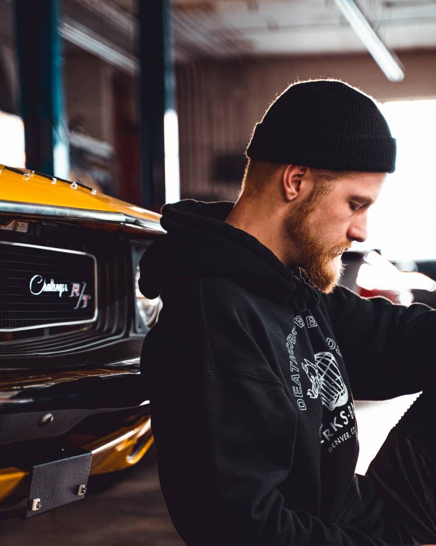 man with beard inspecting a classic vehicle