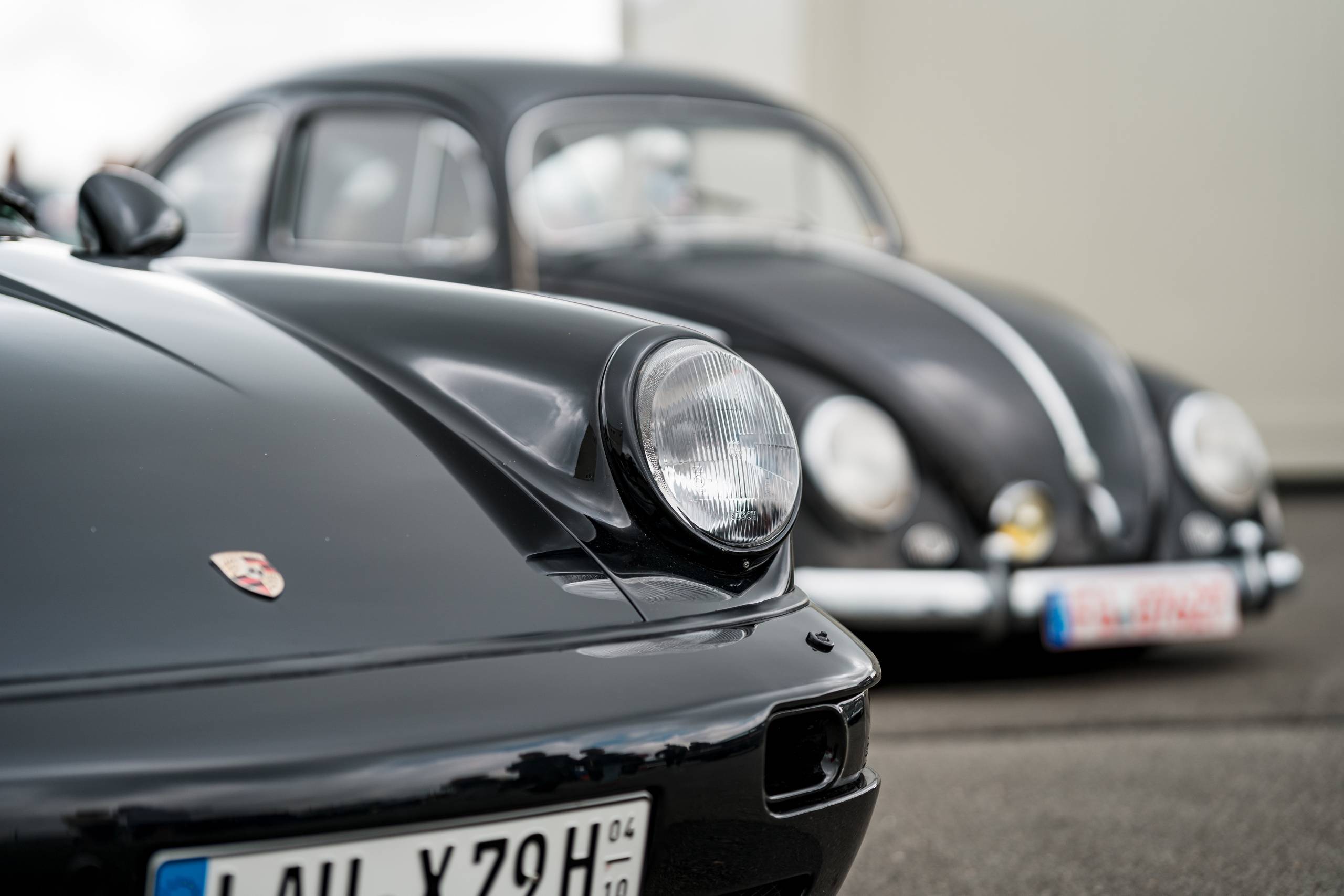 black Porsche 911 and volkswagen beetle