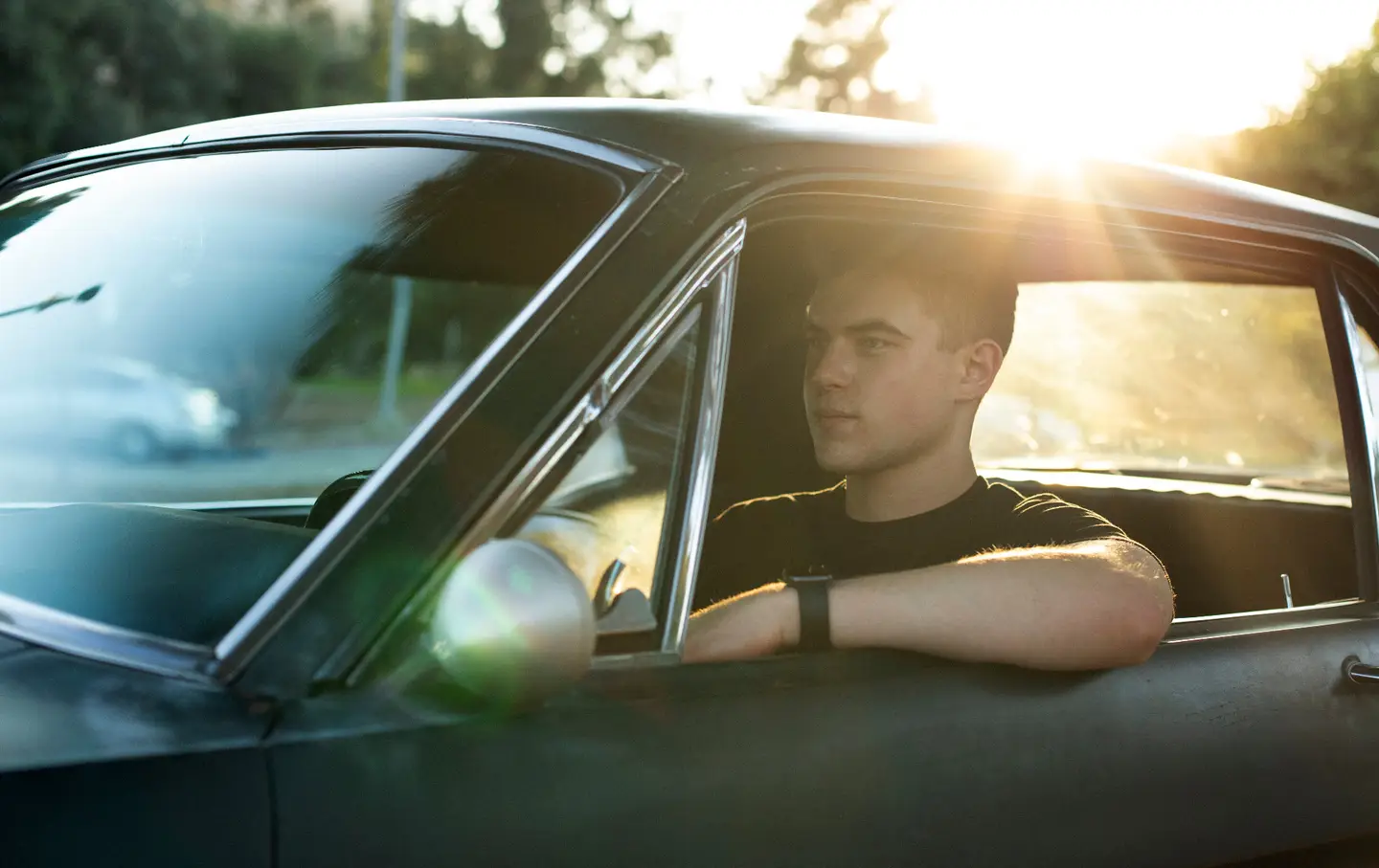 young man driving a collector car